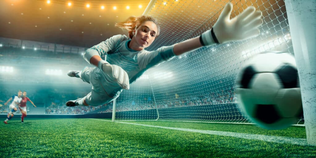 Female Soccer Goalkeeper Catch The Ball On A Professional Soccer Stadium. Girls Playing Soccer